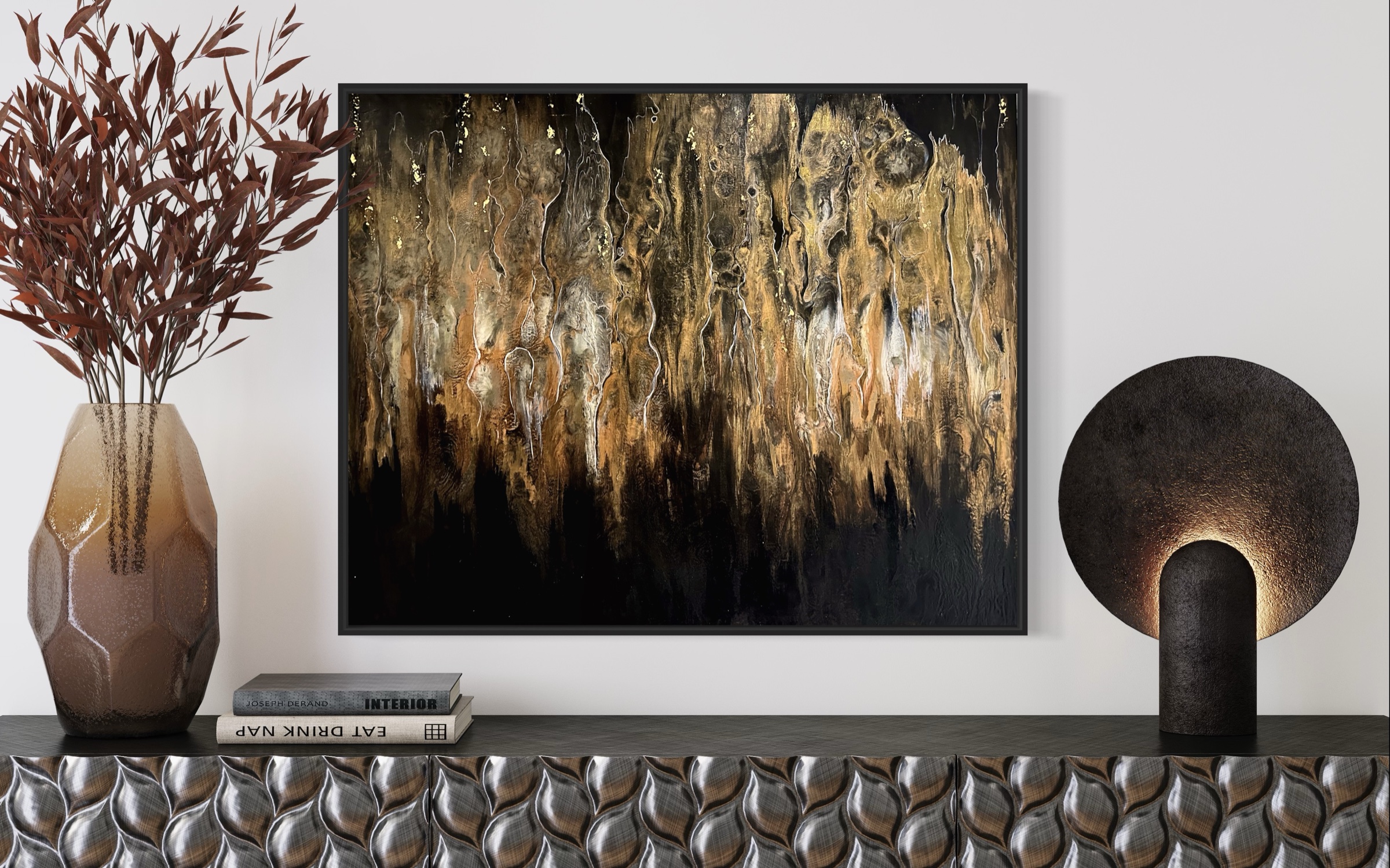 Black and gold resin artwork above a console with a sculptural lamp