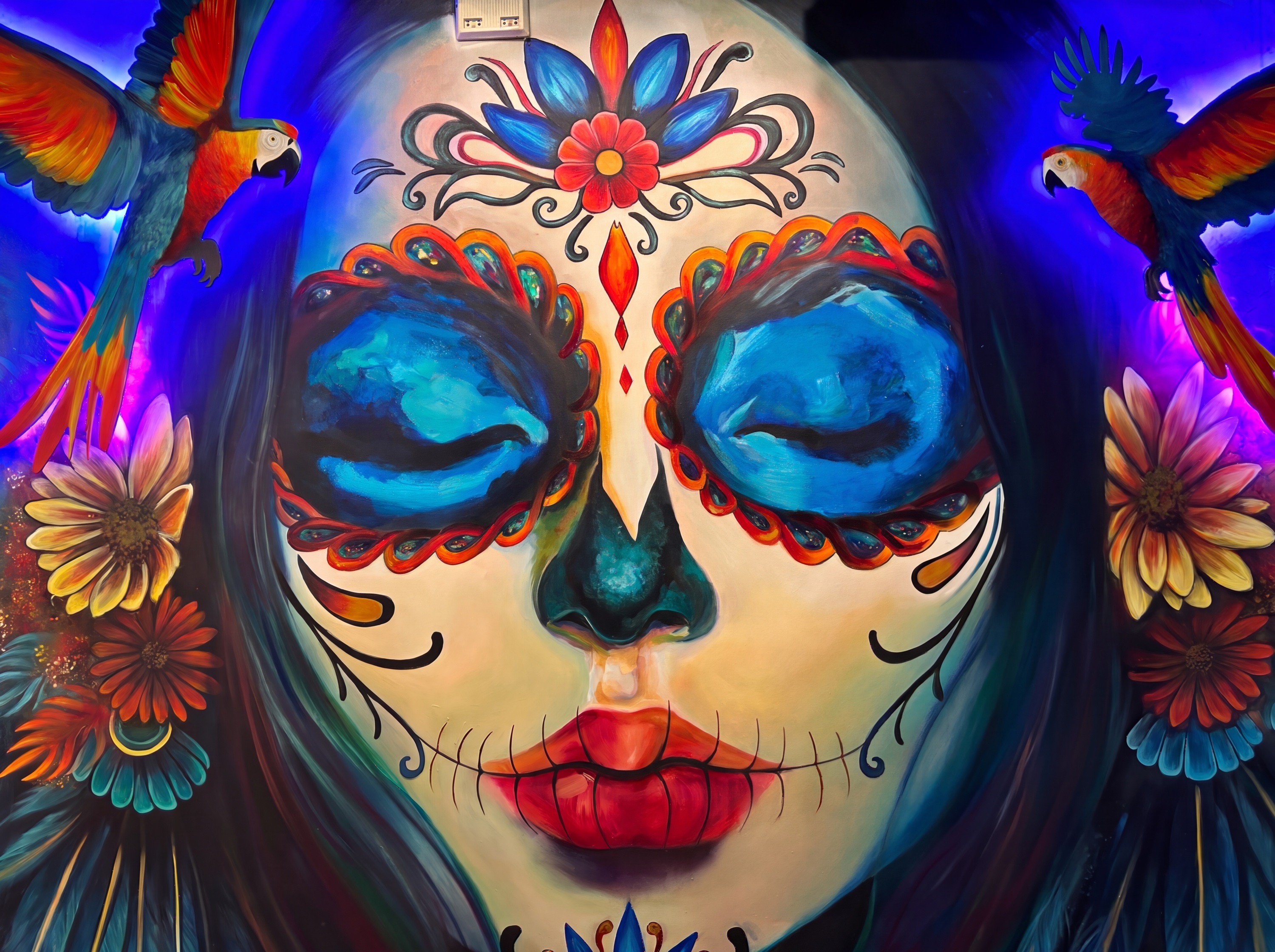 Día de Muertos — mural of a woman with sugar-skull face paint and parrots in Toronto, Canada