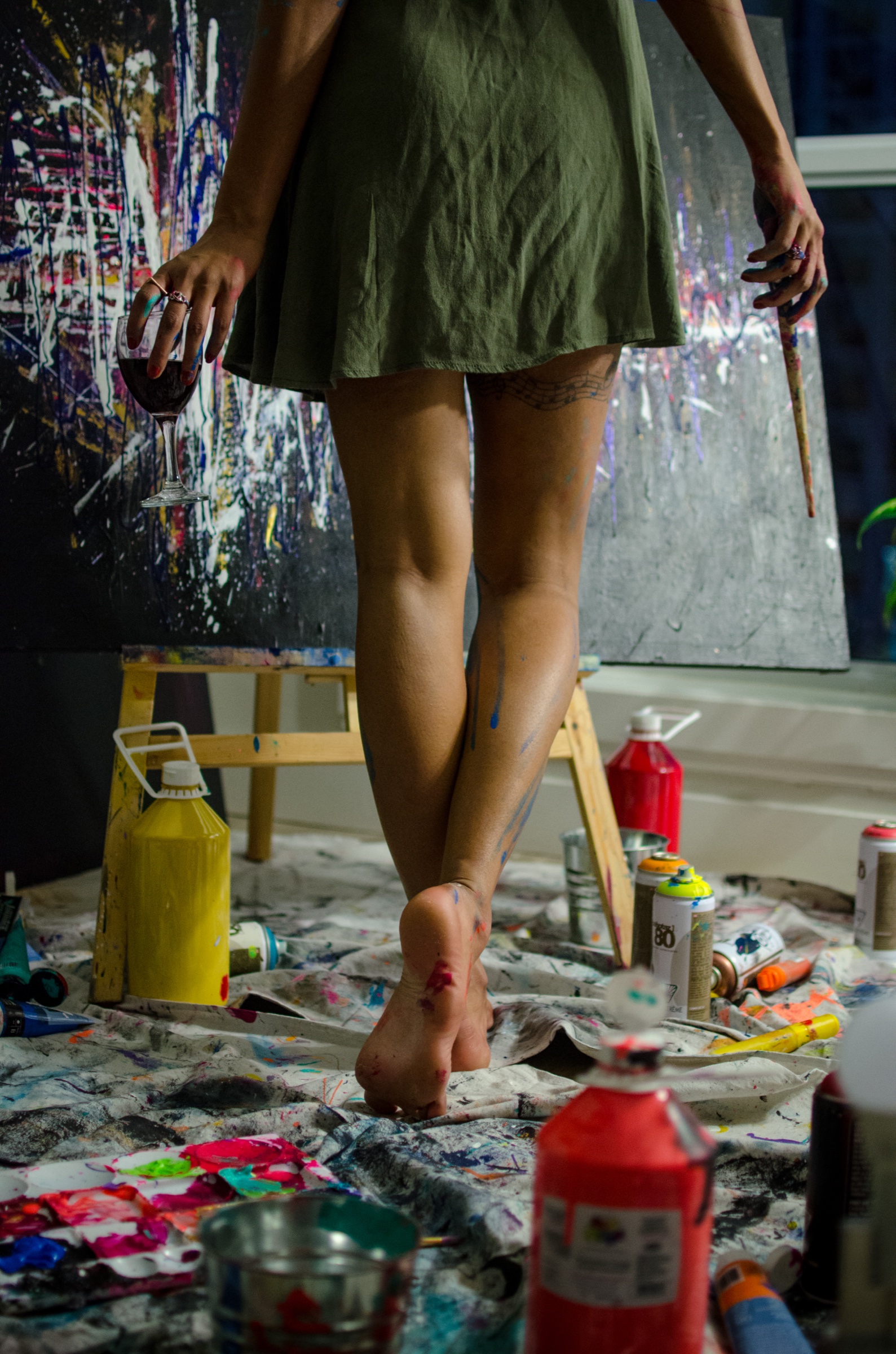 Faith walking barefoot through her paint-covered studio