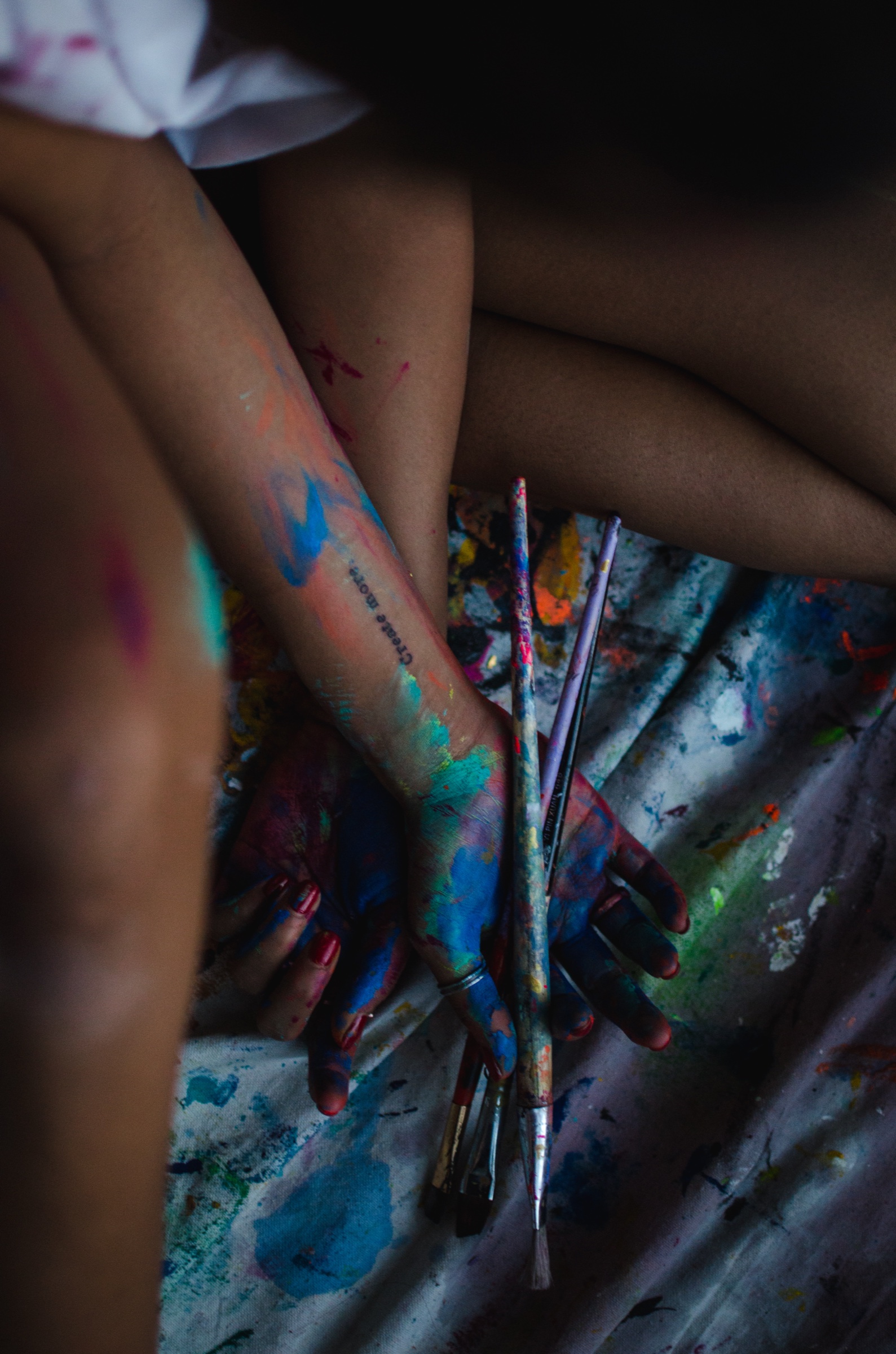 Faith holding paintbrushes with paint-covered hands