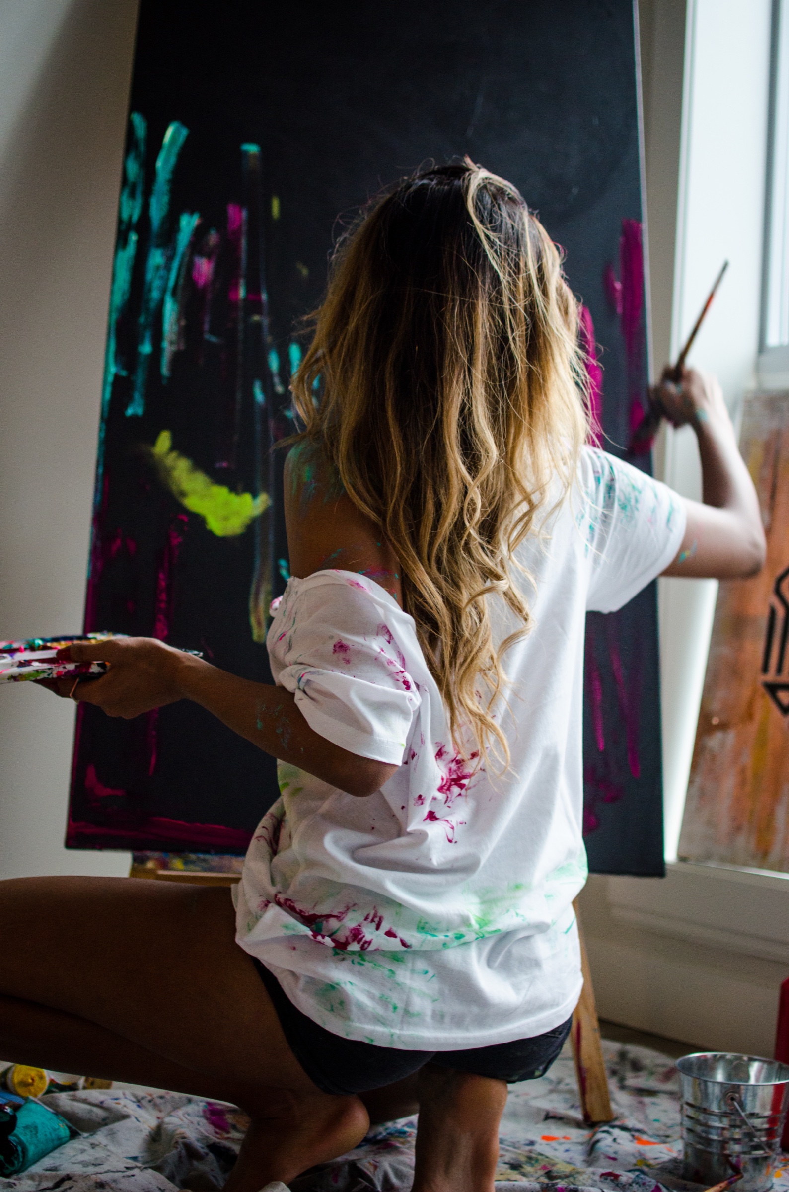 Faith painting a large canvas in her studio