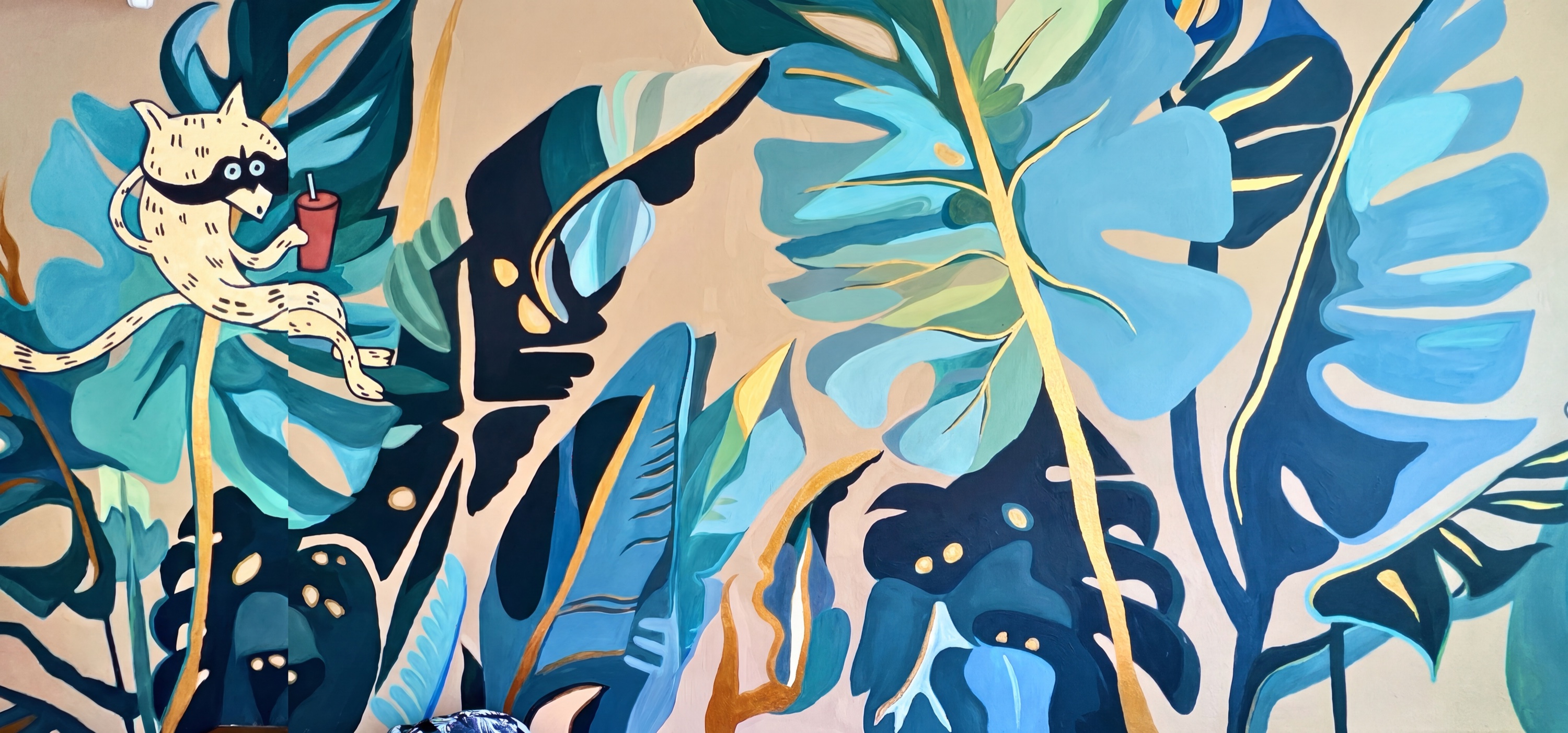 Tropical wall mural with monstera leaves and a raccoon in teal and gold, Playa Del Carmen, Mexico
